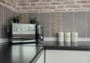 a kitchen with a black counter top with a microwave at Berwick Apartment by Klass Living Coatbridge in Coatbridge