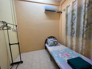 Habitación pequeña con cama y cortina en Permai’s Stay, en Sibu