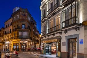 a city street with buildings and a clock tower at La Rosa de la Alfalfa in Seville