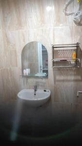 ein Bad mit einem Waschbecken und einem Spiegel in der Unterkunft Apartemen Skylounge Makassar in Sudiang
