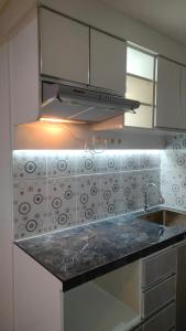 a kitchen with a sink and a stove at Apartemen Skylounge Makassar in Sudiang