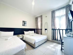 una camera d'albergo con due letti e una finestra di Asphodel Inn a Singapore