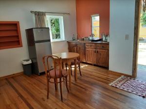 a kitchen with a table and a refrigerator at Japie's Yard Wanderer's Inn in Swakopmund