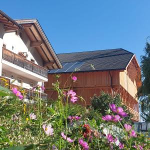 un edificio con una valla y flores delante de él en Planitzhof en Castelrotto
