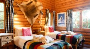 a bedroom with two beds in a log cabin at Beaver Creek Lodge in Aviemore