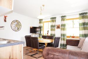 kuchnia i salon ze stołem i kanapą w obiekcie Ferienwohnung Aignerhof w mieście Schellgaden