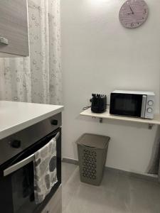cocina con microondas y reloj en la pared en Piccola Flo rooms, en Cagliari 19 fotos más