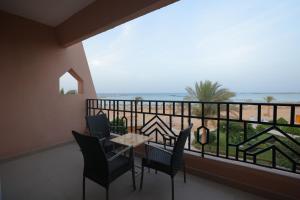einen Balkon mit einem Tisch und Stühlen sowie Meerblick in der Unterkunft Jasmine Palace Resort in Hurghada