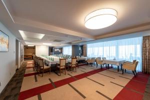 a dining room with tables and chairs and a large window at Hotel Glamour in Kaluža +47 photos