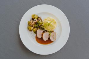um prato de alimentos com carne e legumes sobre uma mesa em Hotel Glamour em Kaluža