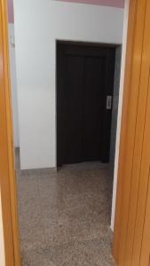 un couloir avec une porte noire dans une chambre dans l'établissement Casetta Cavour, à Pantelleria