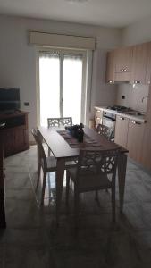 une cuisine avec une table en bois, des chaises, une table et une table dans l'établissement Casetta Cavour, à Pantelleria