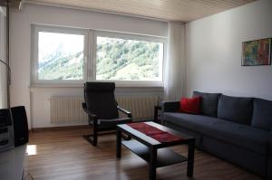 uma sala de estar com um sofá, uma cadeira e uma janela em Salve 9 em Leukerbad