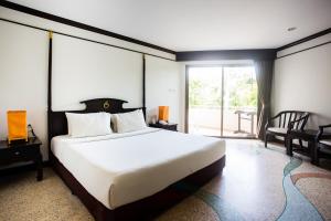 een slaapkamer met een groot bed en een groot raam bij Golden Beach Resort in Ao Nang Beach