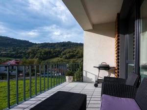 a balcony with chairs and a grill on a house at Beskid Apartment in Szczyrk