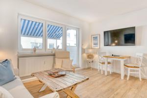 un soggiorno con divano e tavolo di Urlaubsmanufaktur a Norderney