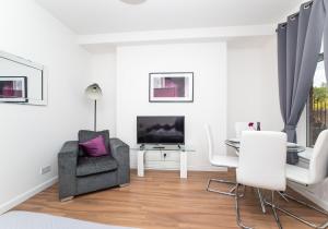 a white living room with a chair and a table at Cosy Apartment by Klass Living Bellshill in Bellshill