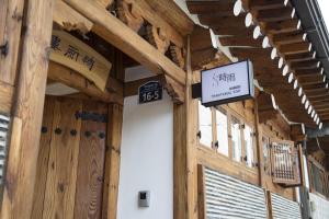 a wooden building with a sign on the side of it at Renewal Open!!! Entire Place, Traditional Stay Xiwoo , 時雨 시우 한옥독채 in Seoul +34 photos