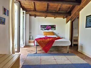 Un dormitorio con una cama con una manta roja. en Agriturismo la Casa del Vecchio Mulino, en Carassai