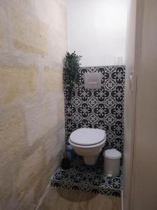 y baño con aseo y azulejos blancos y negros. en La Maison Libourne, 4 pers, Hypercentre, rue calme, en Libourne