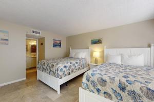 a bedroom with two beds and a bathroom at 210 - Sandy Shores in St. Pete Beach