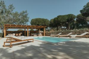a pool with lounge chairs and a pavilion next to at Casalot Almancil in Almancil