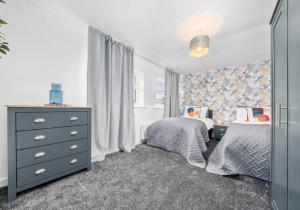 a bedroom with two twin beds and a dresser at West End House by Klass Living Bellshill in Bellshill