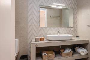 ein Bad mit einem Waschbecken und einem Spiegel in der Unterkunft AMINA APARTMENTS in Zakynthos