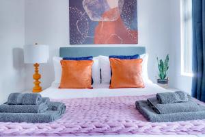 a bedroom with a bed with colorful pillows on it at Modern 2 bedroom flat - 15 minutes to Liverpool in Birkenhead