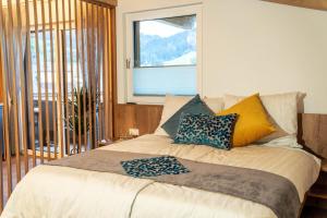 a bedroom with a bed with pillows and a window at Haus Gschösser in Reith im Alpbachtal