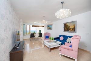 un salon avec un canapé bleu et des chaises roses dans l'établissement Fidalsa Bella Vista, à El Campello