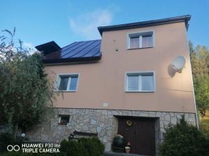 ein Haus mit Sonnenkollektoren an der Seite in der Unterkunft Silvester Drevenica pod Horou in Vyšná Korňa