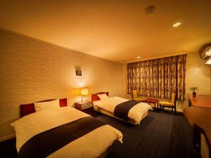 een hotelkamer met 2 bedden en een raam bij Yukai Resort Dogo Saichoraku in Matsuyama