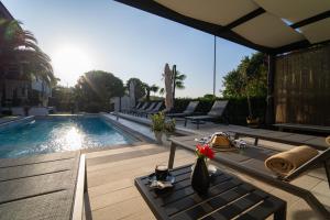 a swimming pool with chairs and a table on a patio at Residence Vaal in Rovinj