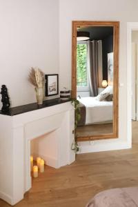 1 dormitorio con chimenea y espejo en Appartement Le Perchoir by La Boîte En Plus, en Senlis