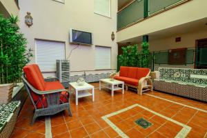 a patio with two chairs and a table and a tv at Hotel H28 Camas in Camas
