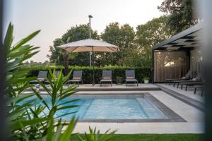 una piscina con sillas y sombrilla en Residence Vaal en Rovinj