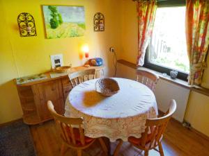kuchnia ze stołem i krzesłami oraz oknem w obiekcie Holiday Home Tennenbronn-1 by Interhome w mieście Tennenbronn