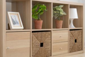 a wooden cabinet with three plants in it at Modern Apartment Close to the Centre of Poznań by Renters in Poznań