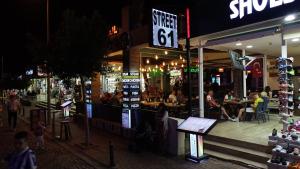 un grupo de personas sentadas fuera de un restaurante por la noche en Street61 Apart Hotel, en Sarigerme
