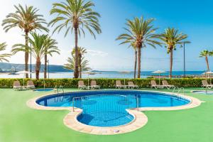 una piscina en un complejo con palmeras en Apartamentos Vista Sur, en Playa de las Américas