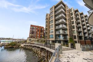 een weergave van een gebouw naast een waterlichaam bij Brand New Building! Modern, Conveniently Located 1 Bedroom Condo. in Victoria