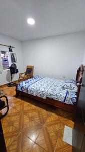 a bedroom with a bed and a wooden floor at Casa familiar barranco in Barranquilla