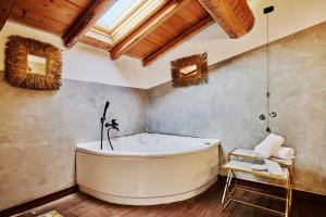 a bath tub in a bathroom with a wooden ceiling at Agriturismo Cascina Mirandola in Como