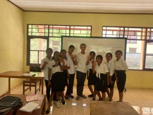 a group of people posing for a picture in a classroom at Lawi Luja Guest House in Kelimutu