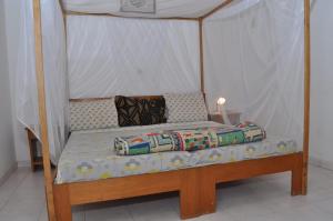 a bed with a canopy in a room at Appartement à Saly in Saly Portudal
