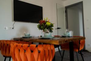 a dining room table with chairs and a television at GreenLeaf Regensburg I Sinzing in Sinzing