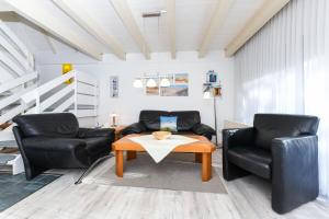 a living room with two chairs and a table at Ferienhaus Deichliebe in Bensersiel