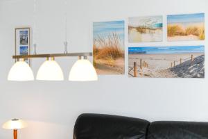 a living room with three pictures on the wall at Ferienhaus Deichliebe in Bensersiel