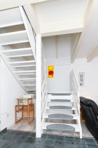 a staircase in a living room with white ceilings at Ferienhaus Deichliebe in Bensersiel +29 photos